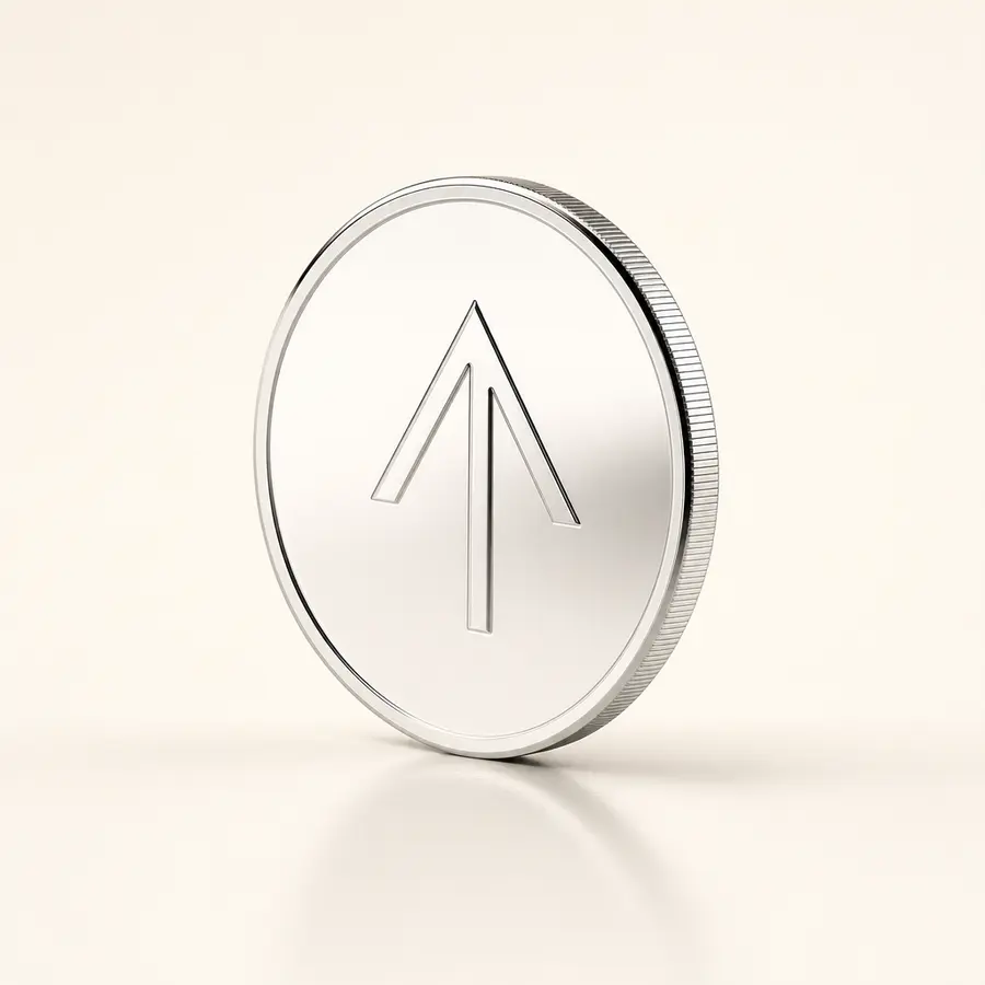 A polished chrome coin engraved with an upward arrow